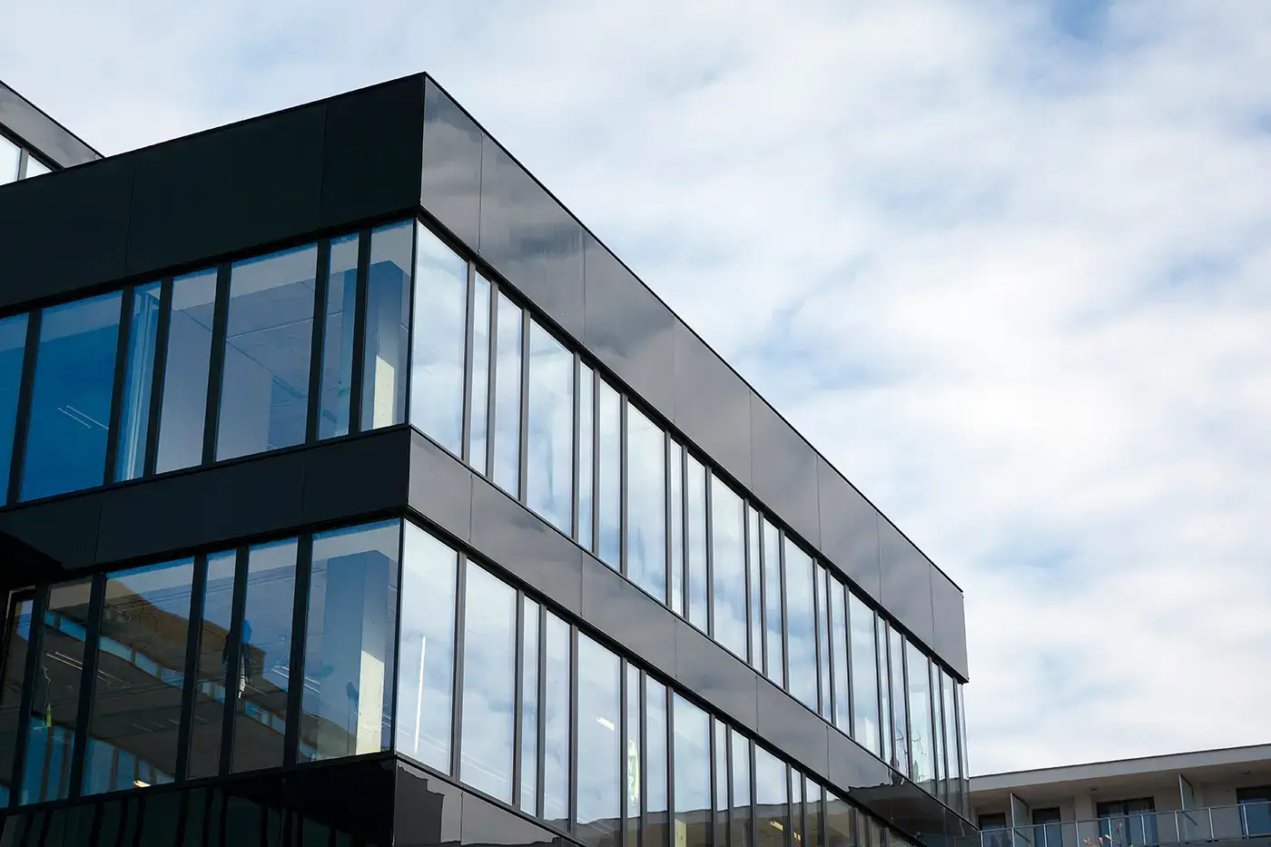 Moderne Glasfassade mit großflächigen Aluminium-Glaselementen – geplant und montiert von B & K Knoop in Nusse.